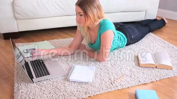 年轻漂亮的金发女郎正在学习她的笔记本电脑视频的预览图