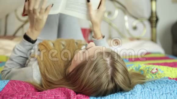 年轻女子在家学习在床上看书的女孩视频的预览图