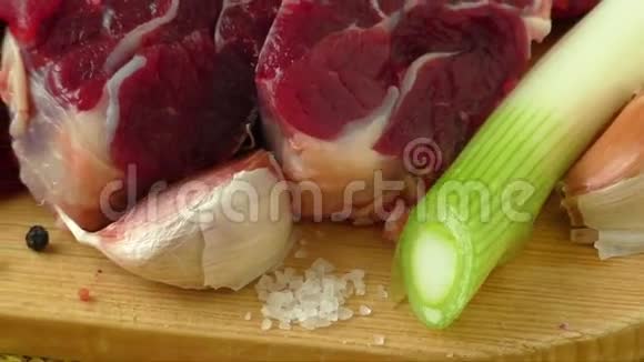 生牛肉与大蒜和洋葱放在木板上视频的预览图