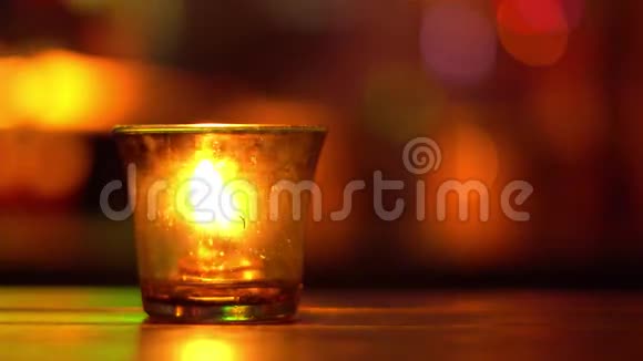 杯子里的蜡烛放在蓝调音乐酒吧的木桌上模糊的后退博克彩色照明4K视频的预览图