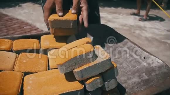 施工现场施工工人从手推车上卸下石材铺贴慢动作视频的预览图