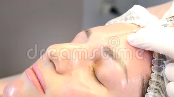 美容诊所美容师用手套制作面部老化注射到女性皮肤上一个女人得到美丽的脸视频的预览图