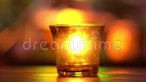 杯子里的蜡烛放在蓝调音乐酒吧的木桌上模糊的后退博克彩色照明4K视频的预览图