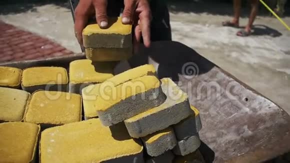 施工现场施工工人从手推车上卸下石块慢动作视频的预览图
