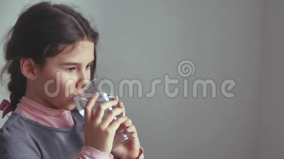 十几岁的女孩从室内的杯子里喝水视频的预览图