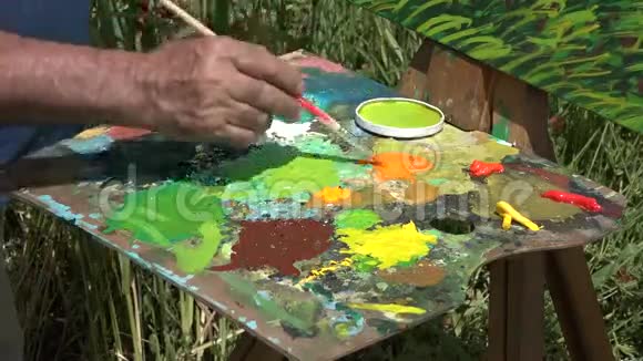 画家在调色板上混合颜色视频的预览图
