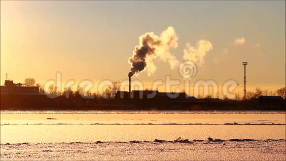 美丽的日落在一条覆盖着冰的冬季河流上视频的预览图