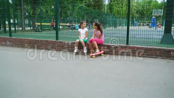 两个孩子在公园户外讲秘密笑视频的预览图
