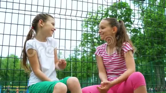 两个孩子在公园户外讲秘密笑视频的预览图