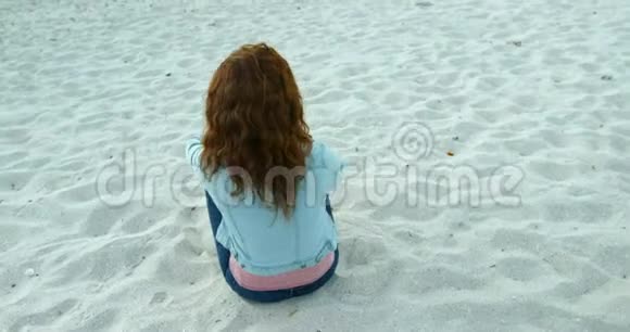 黄昏时在海滩上放松的女人4k视频的预览图
