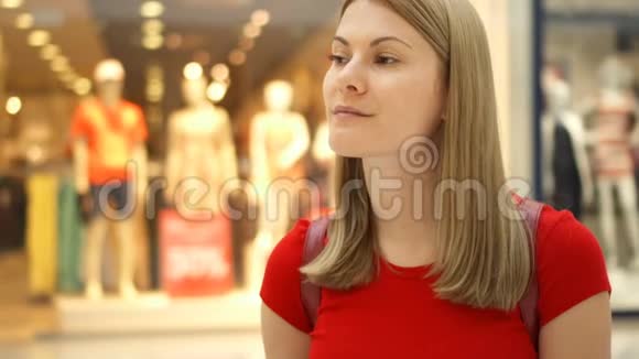 年轻漂亮迷人的女人站在购物中心微笑着购物消费观念视频的预览图