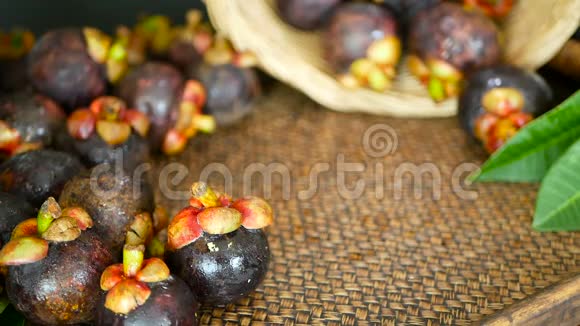 在木桌上看到新鲜美味的收获芒果篮子里有泰国有机紫果视频的预览图