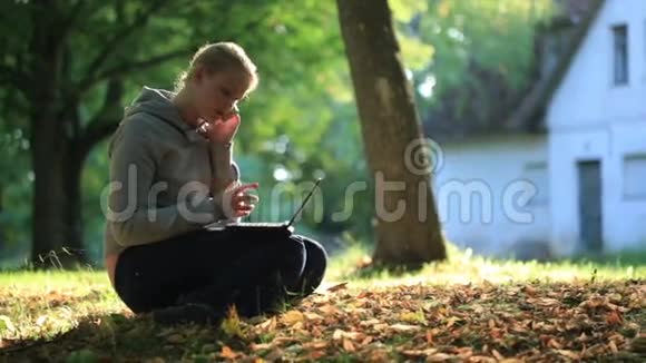 年轻女子坐在户外的地上视频的预览图