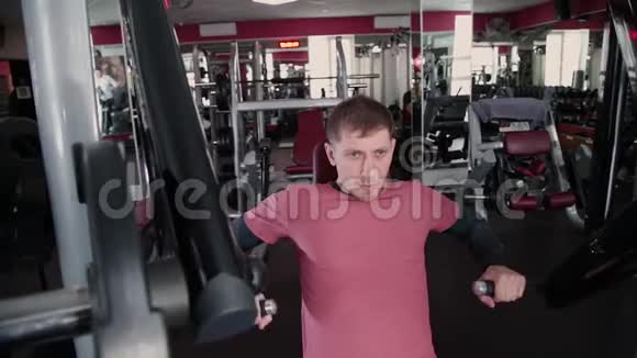 运动和有吸引力的人在健身房的模拟器上训练胸肌视频的预览图
