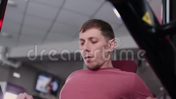运动和有吸引力的人在健身房的模拟器上训练胸肌视频的预览图