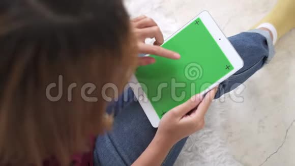 年轻的亚洲女性使用带有绿色屏幕的黑色平板设备视频的预览图