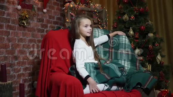 坐在圣诞树椅子上的小女孩视频的预览图