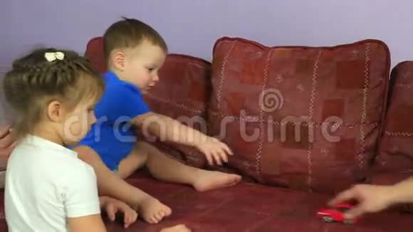 小男孩把机器卷在沙发上快乐的家庭游戏视频的预览图