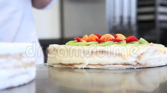 糕点厨师用鲜奶油准备水果蛋糕视频的预览图