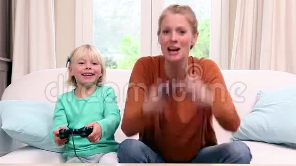 可爱的小女孩和妈妈玩电子游戏视频的预览图
