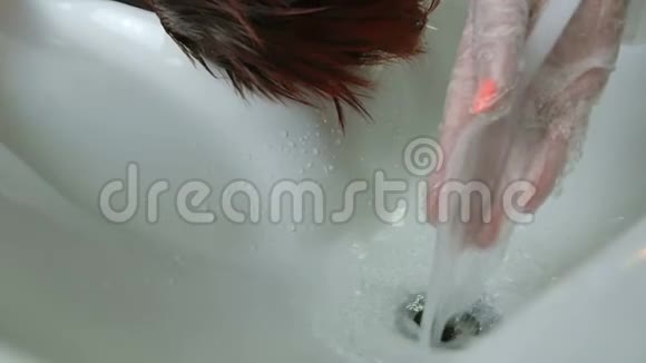 戴手套的理发师洗头发特写视频的预览图