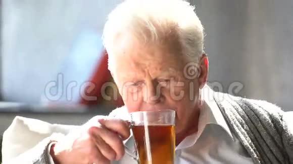 一个老白种人在现代公寓里喝着美味的茶视频的预览图