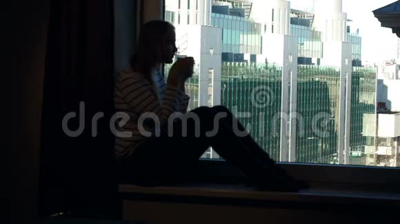 女人在窗台上和城市一起喝咖啡视频的预览图
