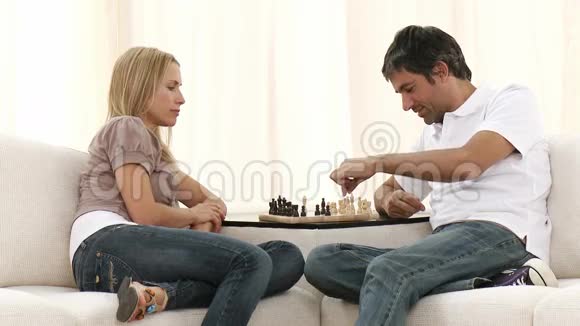 一对夫妇在客厅的沙发上下棋视频的预览图