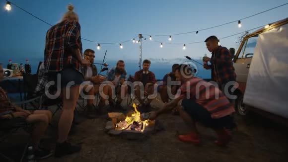 朋友在黄昏的篝火上煎香肠视频的预览图