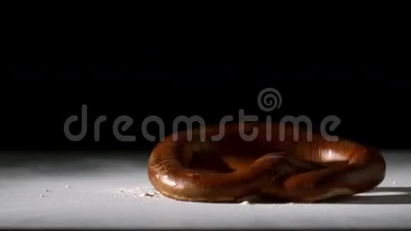 椒盐卷饼落在黑色背景的面粉上视频的预览图