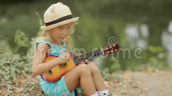 可爱的戴草帽的小女孩在玩玩具视频的预览图