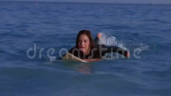 漂亮的女人在冲浪板上划水视频的预览图