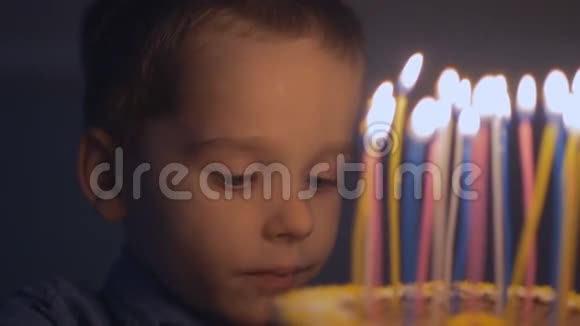一个小男孩在慢动作地吹灭生日蛋糕上的蜡烛之前许了个愿视频的预览图
