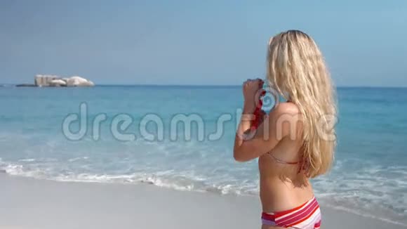 快乐的金发美女在海滩喝鸡尾酒视频的预览图