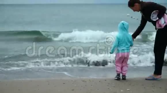 小女孩和她妈妈在海滩上玩耍视频的预览图