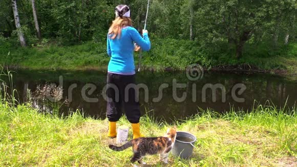 女人鱼在池塘里猫在脚边产卵休闲时光视频的预览图