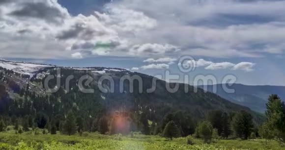 山顶后面云景的时间流逝雪岩石悬崖和深蓝色的天空高空视频的预览图
