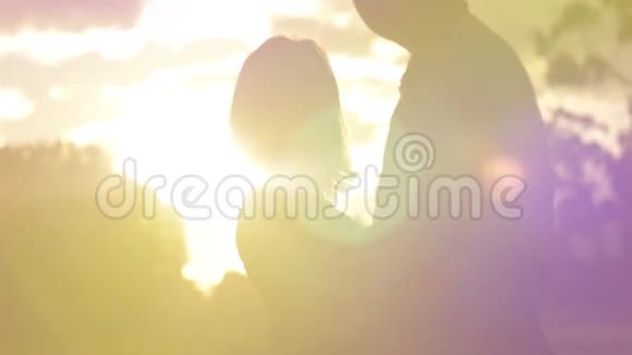 日落时分一对年轻夫妇在爱情公园的浪漫日落慢动作视频的预览图
