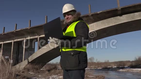 工程师在桥附近用笔记本电脑行走视频的预览图