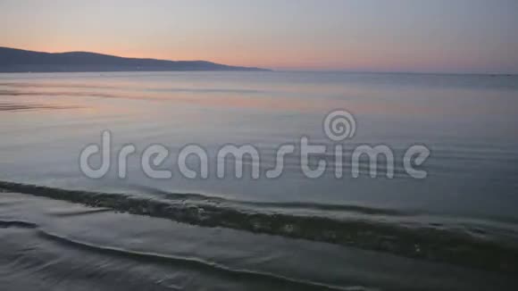 太阳从地平线上升起清晨的沙滩上掀起海浪视频的预览图