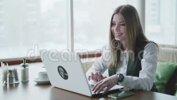 一位在咖啡馆里用手提电脑工作的妇女视频的预览图