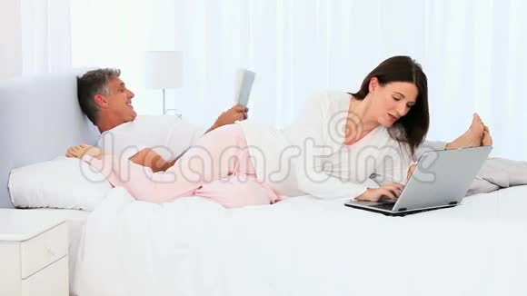 女人给丈夫看她的笔记本电脑视频的预览图