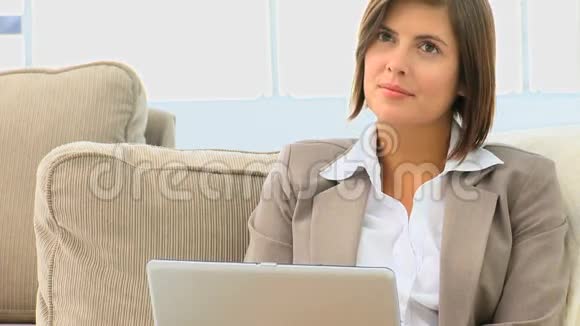 漂亮的黑发女人在她的笔记本电脑上工作视频的预览图