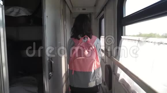 十几岁的女孩带着背包在火车车厢里散步交通运输铁路概念小女孩走路视频的预览图