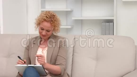 创意女商人在剪贴板上做笔记视频的预览图