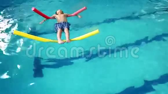可爱的小男孩漂浮在游泳池里视频的预览图