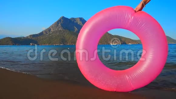 粉红色的充气圈在海滩上视频的预览图