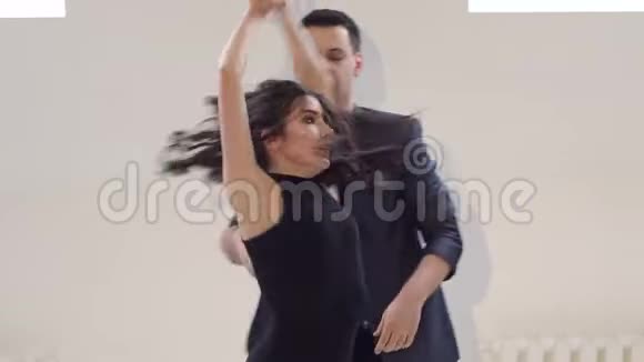 在白色房间里跳舞的漂亮夫妇视频的预览图