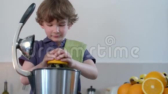 年轻有趣的白种人男孩在厨房用电榨汁机和微笑制作鲜橙果汁视频的预览图