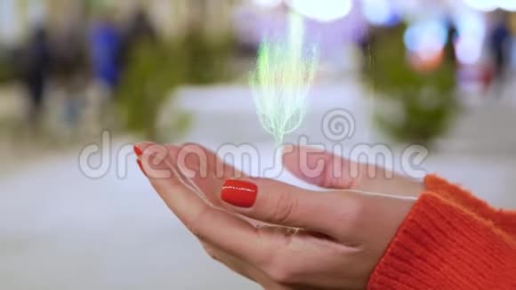 女性手拿着植物的概念全息图视频的预览图
